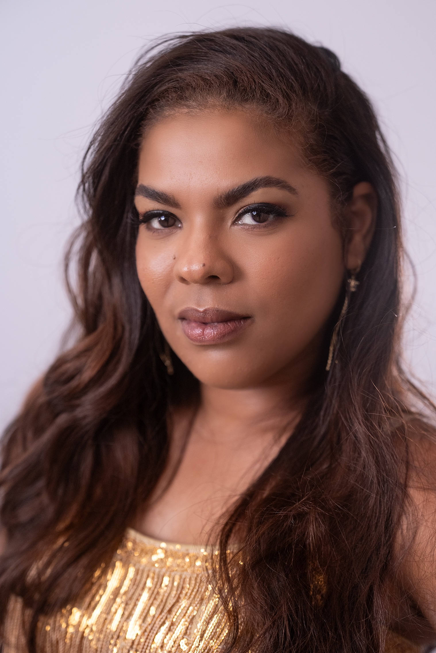 Retrato de Lianne Liz Milan Hernandez, concursante número 32 de Miss Nova Fémina, con elegante vestido dorado.