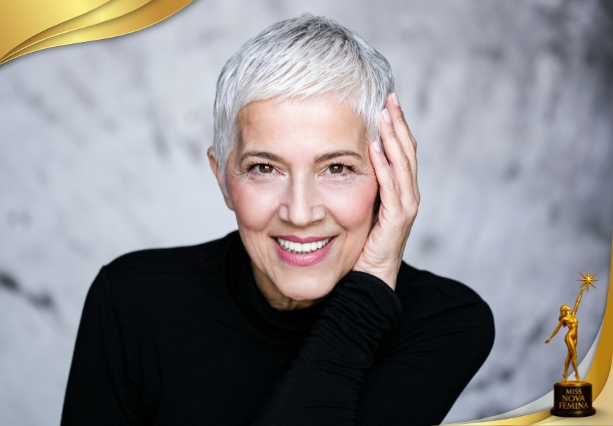 Mujer madura de cabello canoso sonriendo con elegancia en Miss Nova Femina.