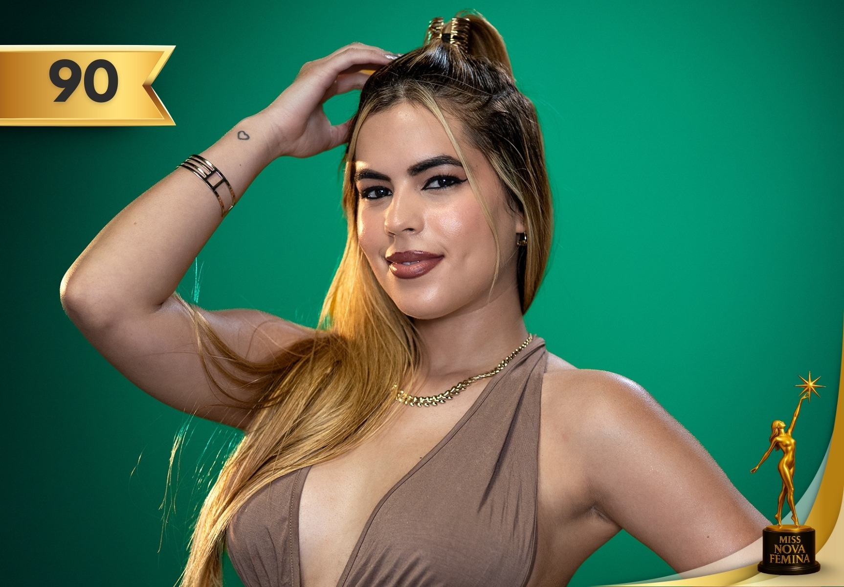 Isis Aloma Medina, concursante #90 de Miss Nova Fémina 2025, posando con un vestido marrón elegante frente a un fondo verde.