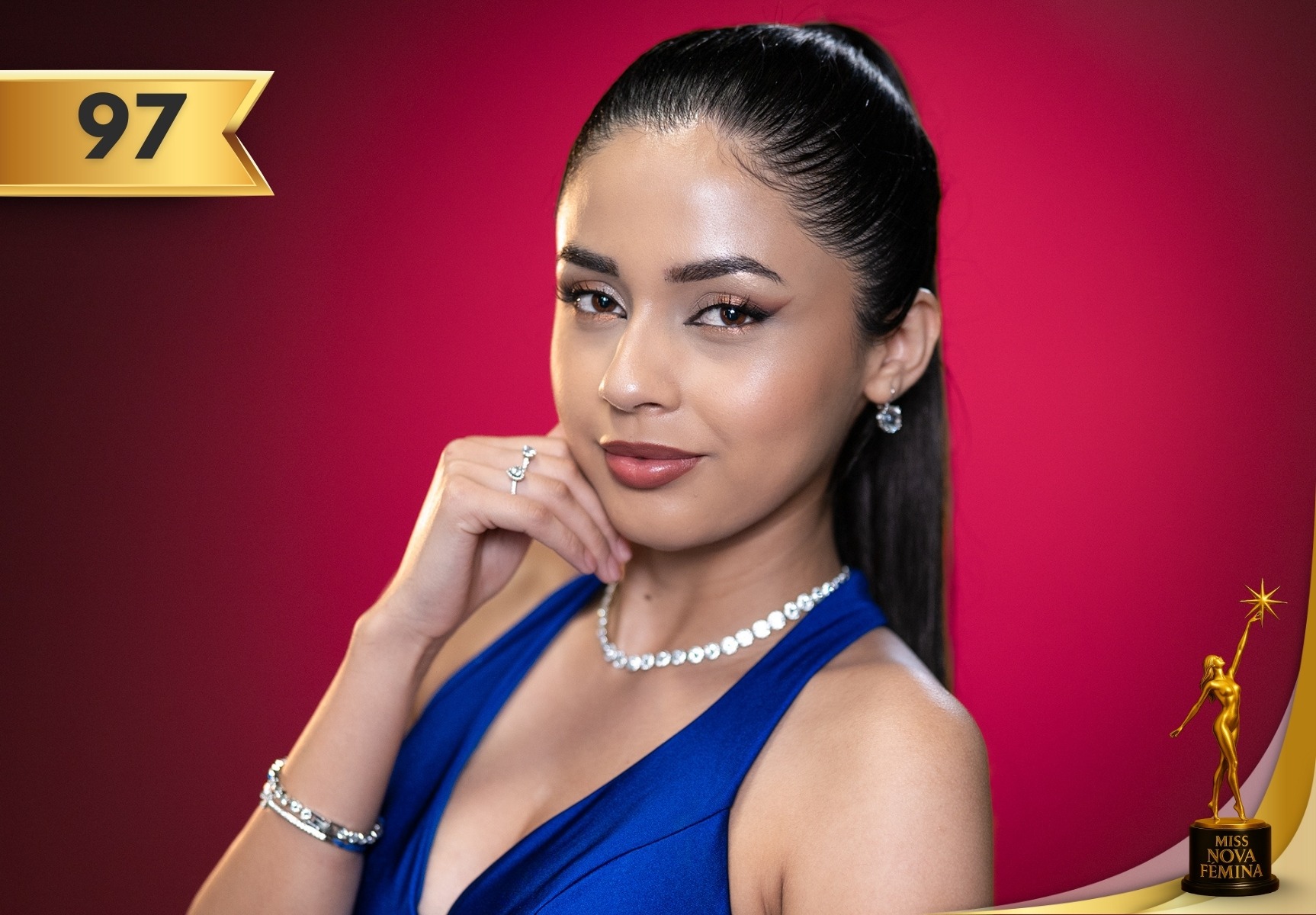 Valeria Sophia Veliz Aranda, concursante #97 de Miss Nova Fémina 2025, luciendo un vestido azul elegante y joyas brillantes frente a un fondo fucsia.