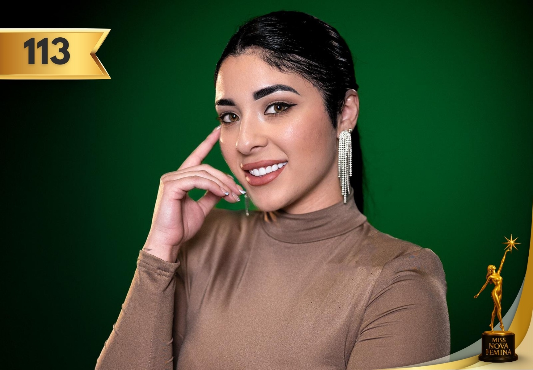Irayne Salgado Correa, concursante #113 de Miss Nova Fémina 2025, posando con un vestido beige de manga larga y aretes largos brillantes frente a un fondo verde.