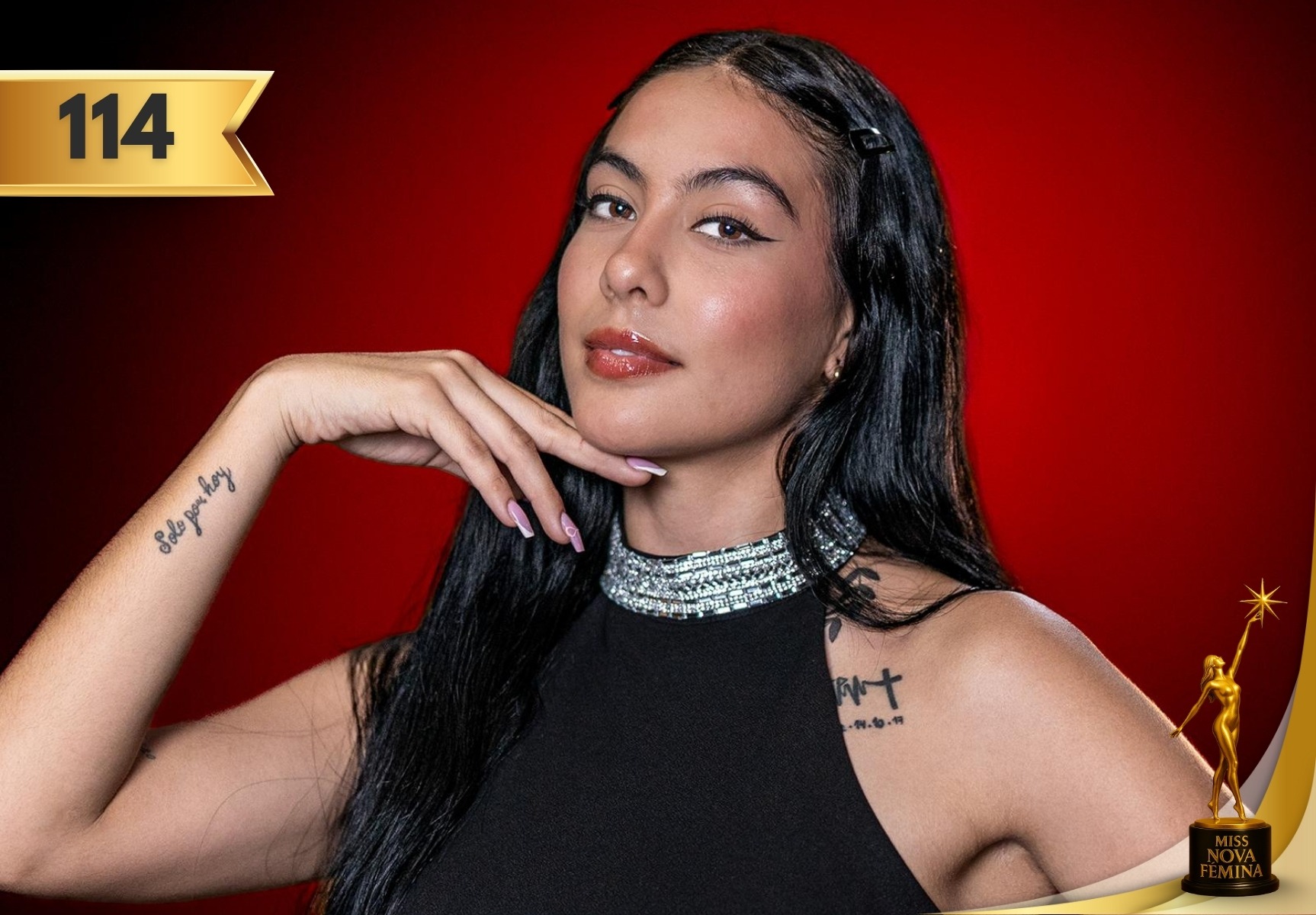 María Camila Reyes Moreno, concursante #114 de Miss Nova Fémina 2025, posando con un vestido negro elegante frente a un fondo rojo.