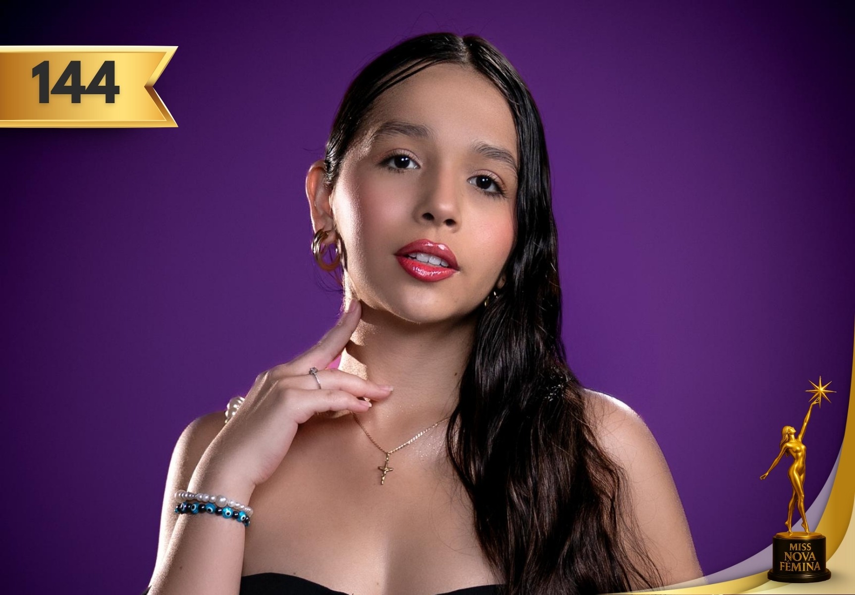 Gloria de la Caridad Agüero Hidalgo, concursante #144 de Miss Nova Fémina 2025, posando con un vestido negro y accesorios delicados frente a un fondo púrpura.