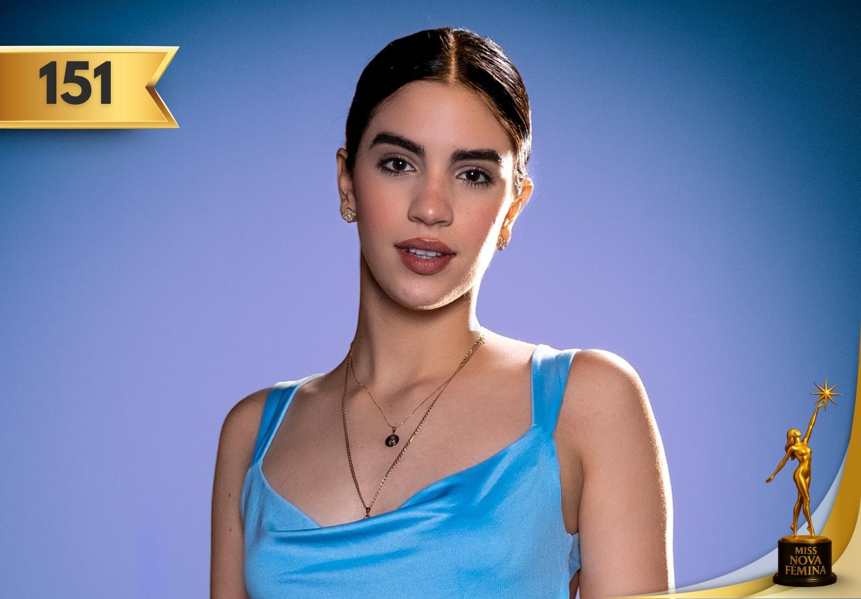 Yisdelys de la Caridad Pérez Chaos, concursante #151 de Miss Nova Fémina 2025, posando con un vestido azul satinado frente a un fondo azul violeta.