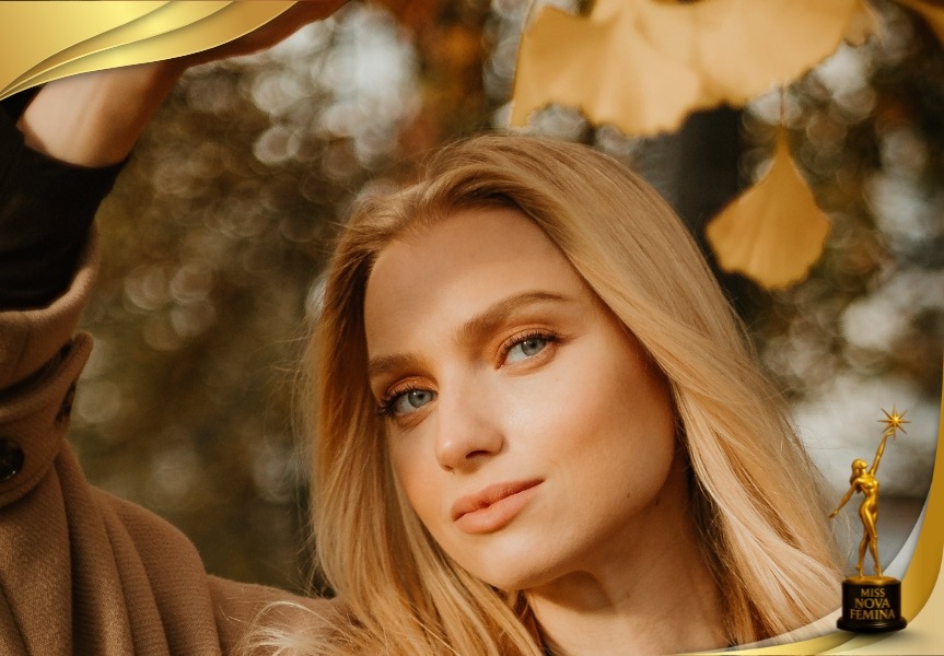Retrato oficial de concursante de Miss Nova Fémina 2025, mujer rubia con mirada serena, posando en un entorno natural con hojas otoñales.