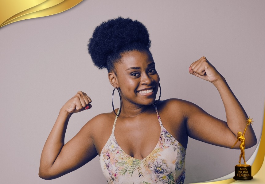 Retrato oficial de concursante de Miss Nova Fémina 2025, posando sonriente con vestido floral y mostrando fuerza con los brazos en alto.