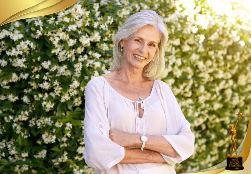 Retrato oficial de modelo de la categoría Miss Fifty en Miss Nova Fémina 2025, posando sonriente con blusa clara frente a un fondo floral.