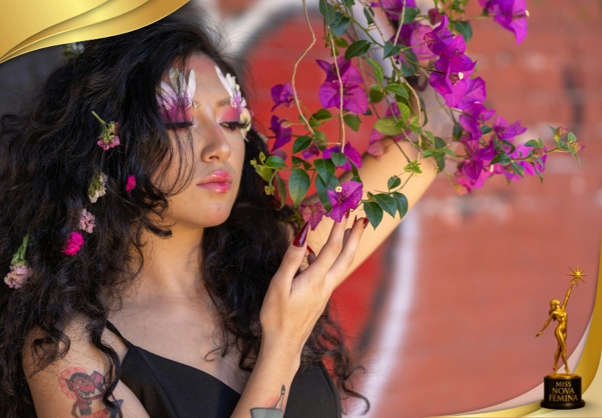Retrato artístico de una concursante de Miss Nova Fémina posando entre flores moradas, con pétalos sobre el rostro y mirada serena, representando la conexión entre la feminidad y la naturaleza.