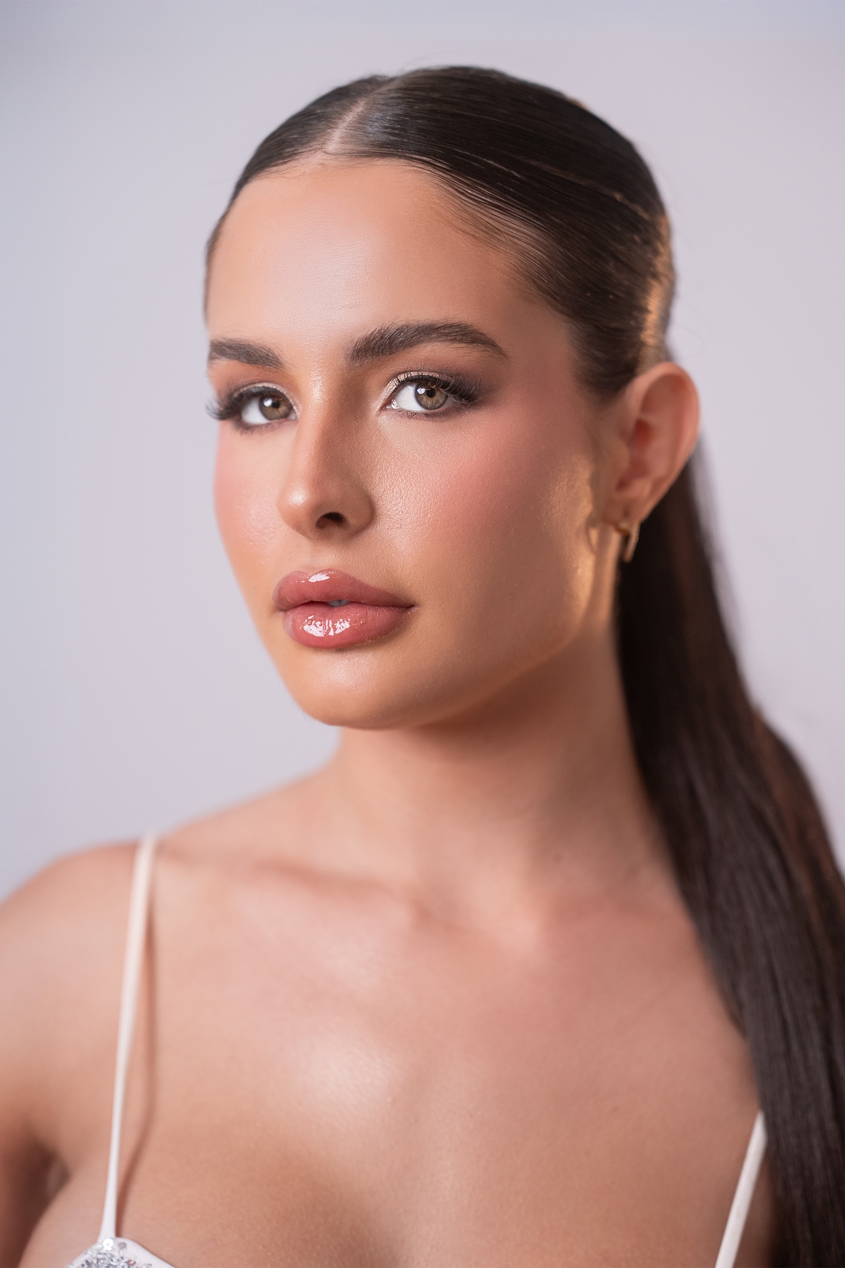 Retrato de Gabriela González Montero, concursante número 12 de Miss Nova Fémina, con maquillaje elegante y peinado recogido.