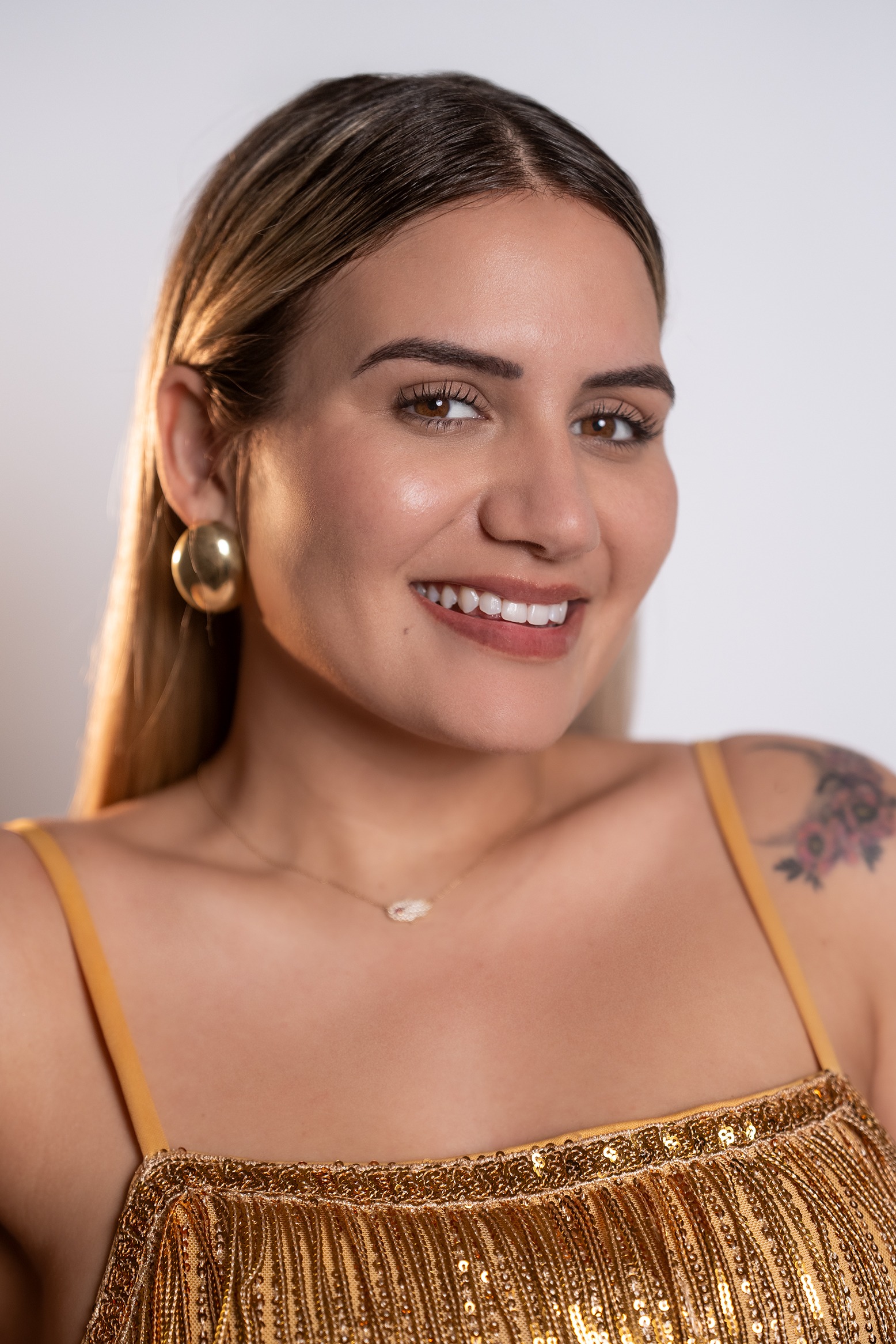 Retrato de Anabel Reyes, concursante número 2 de Miss Nova Fémina, sonriendo con elegancia y luciendo un vestido dorado.