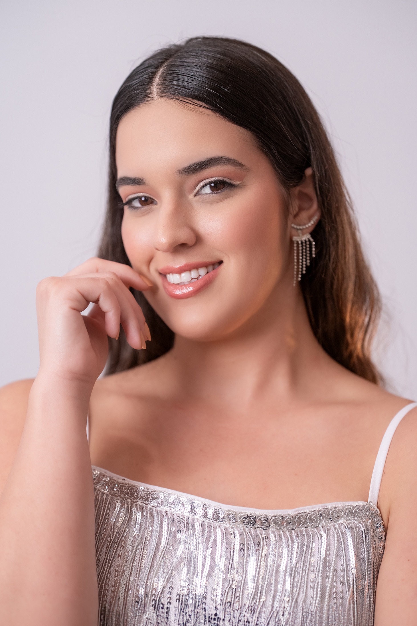 Yarialis Marrero Acosta, candidata #25 de Miss Nova Fémina, posando en retrato profesional con vestido plateado brillante.
