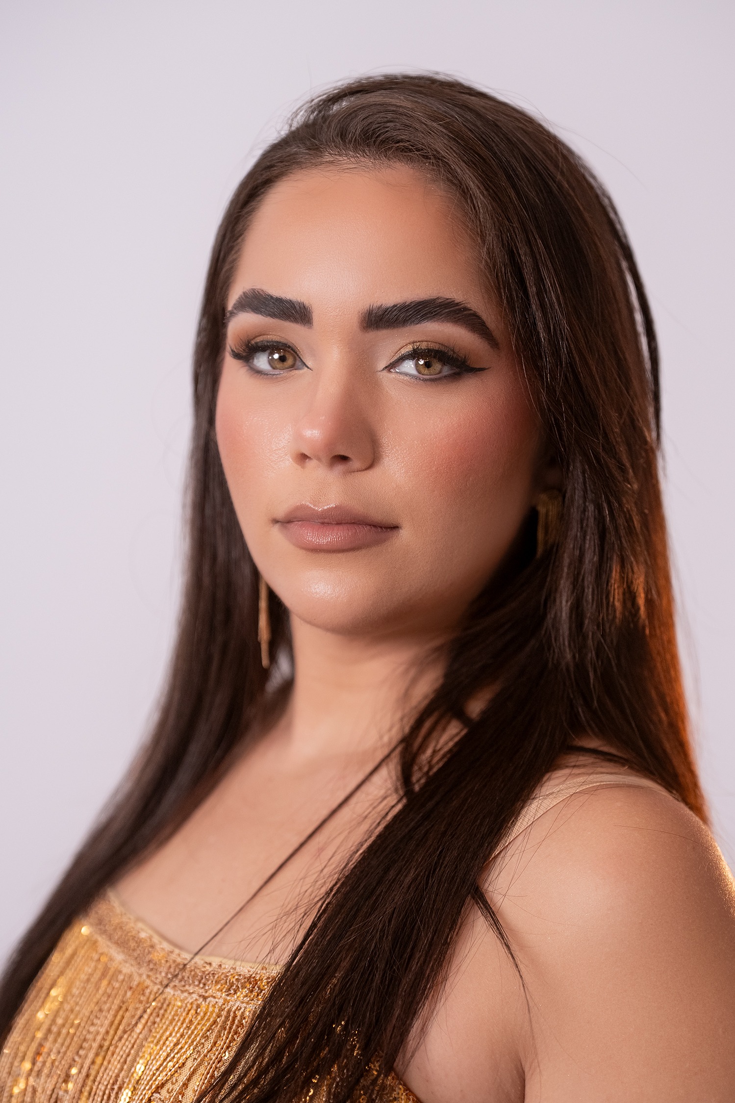 Retrato de Liahtne Mariana López Lemus, concursante número 30 de Miss Nova Fémina, luciendo un vestido dorado elegante.
