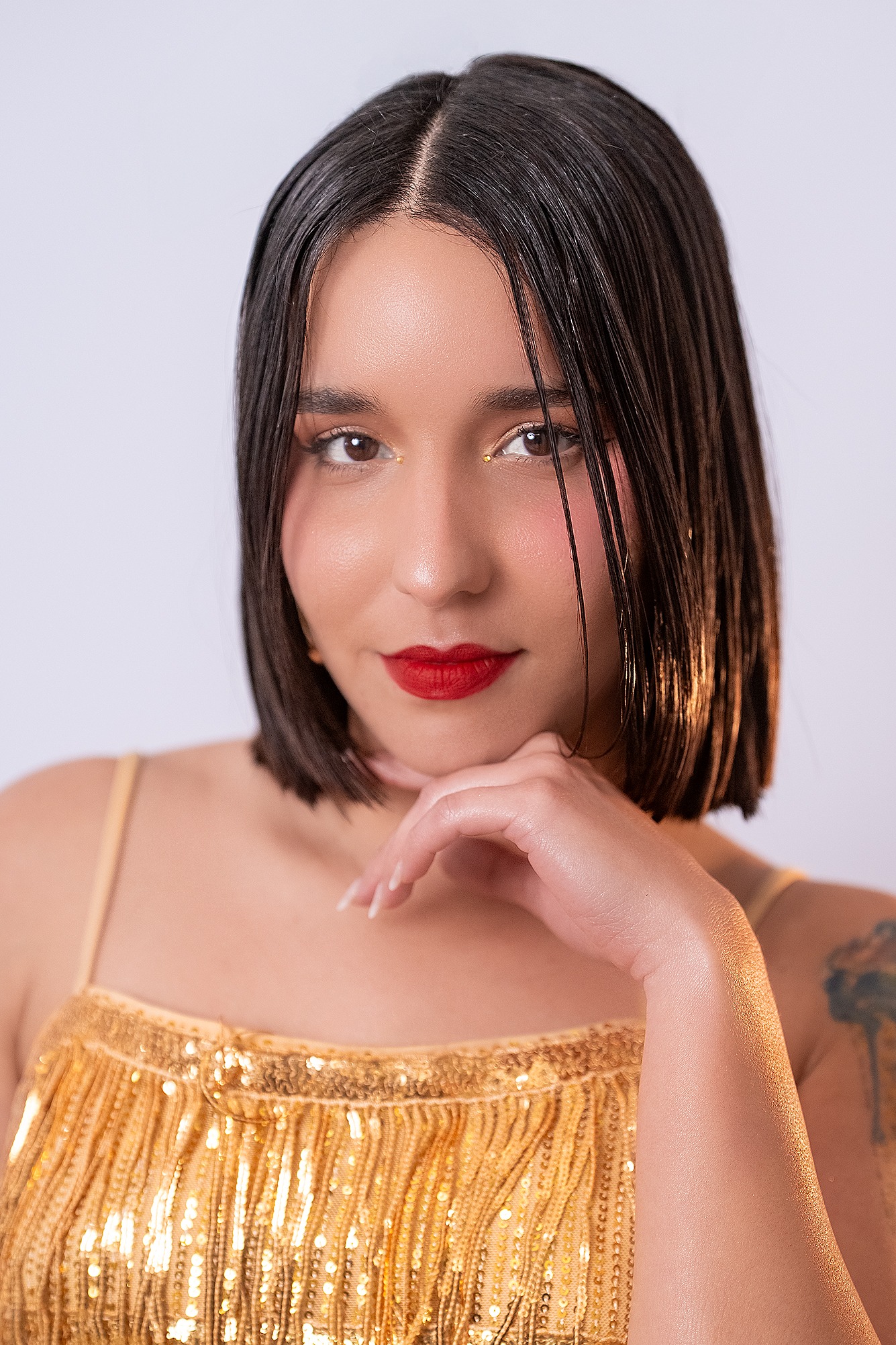 Retrato de Claudia Rachel Hernández Reina, concursante número 38 de Miss Nova Fémina, luciendo un elegante vestido dorado.