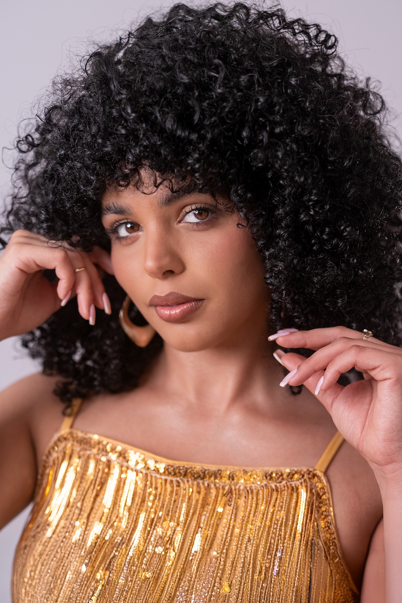 Retrato de Dayanara Barrios Álvarez, concursante número 5 de Miss Nova Fémina, con cabello rizado y vestido dorado.
